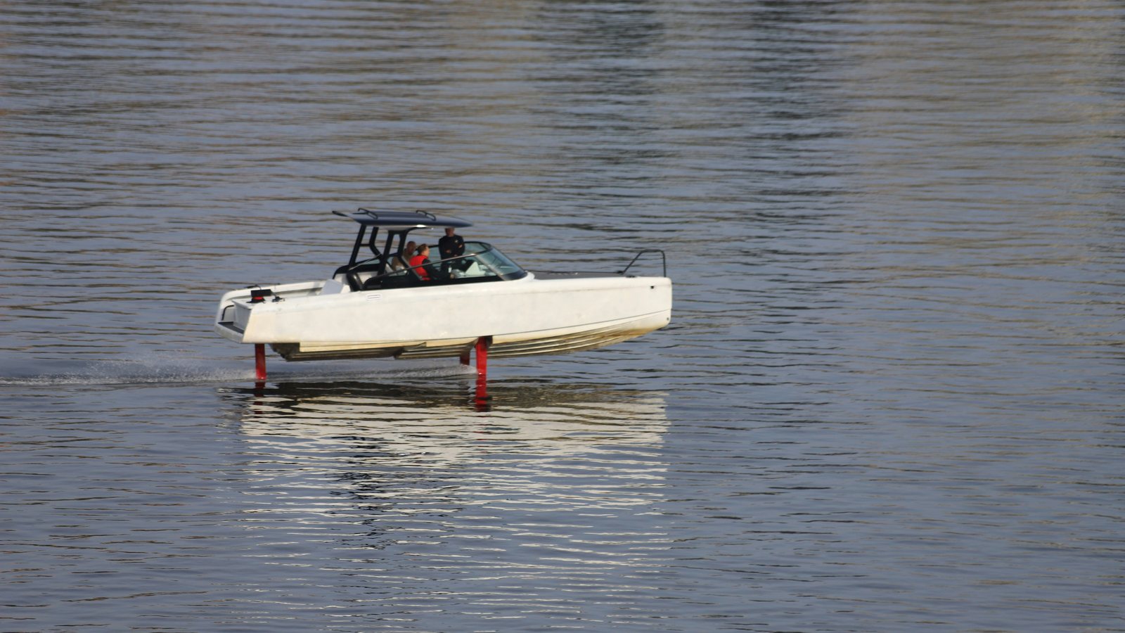 Weißes Candela-Elektroboot gleitet auf roten Tragflächen über dem Wasser